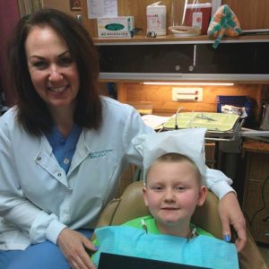 Female dental hygienist with a young male patient